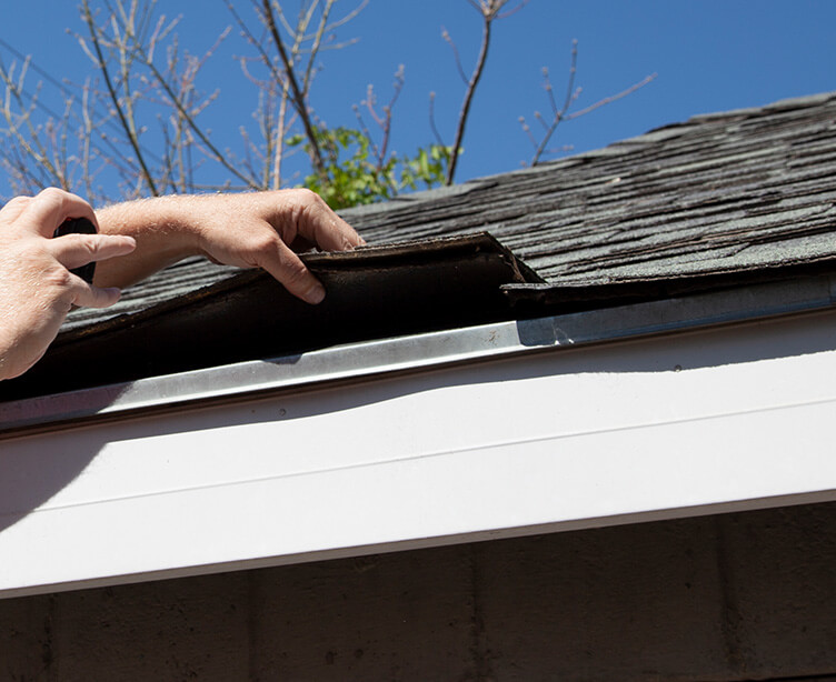 Close up view of a roofer checking the underlying roof